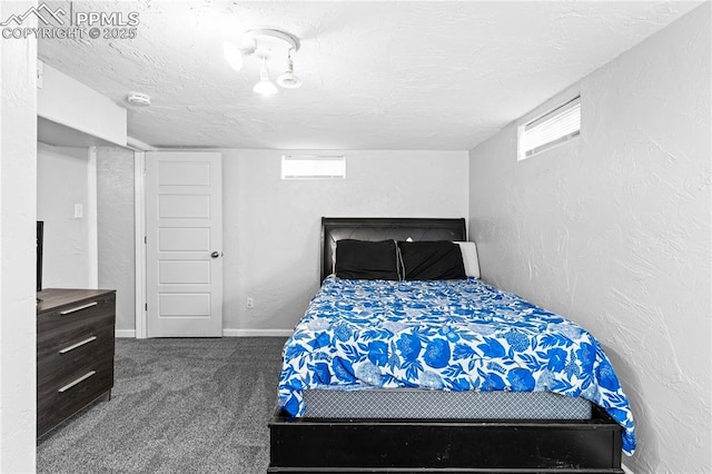 bedroom with dark carpet and a textured ceiling