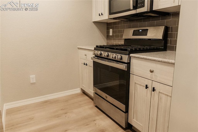 kitchen featuring tasteful backsplash, appliances with stainless steel finishes, and light hardwood / wood-style floors