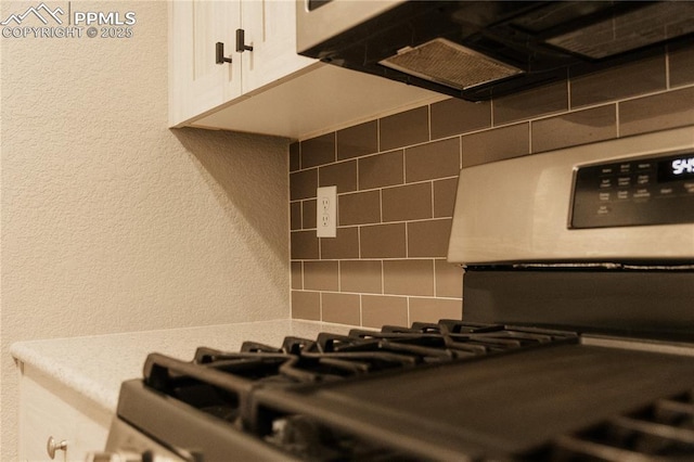 details featuring backsplash and white cabinets