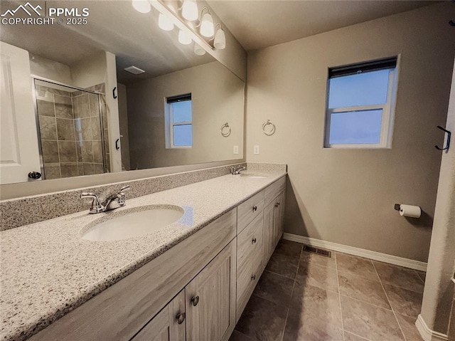 bathroom with a healthy amount of sunlight, vanity, an enclosed shower, and tile patterned floors