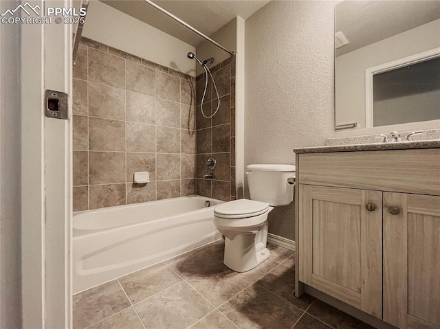 full bathroom featuring vanity, tiled shower / bath combo, tile patterned floors, and toilet