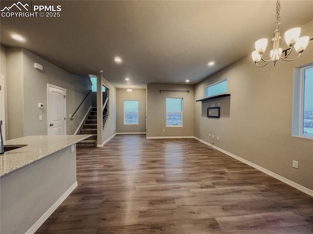 unfurnished living room featuring dark hardwood / wood-style flooring and a chandelier