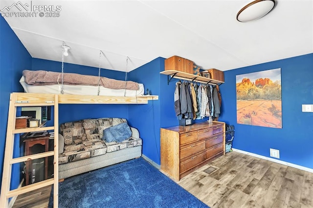 bedroom with wood finished floors and baseboards