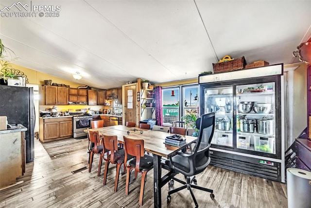 dining area featuring lofted ceiling and light wood-style flooring