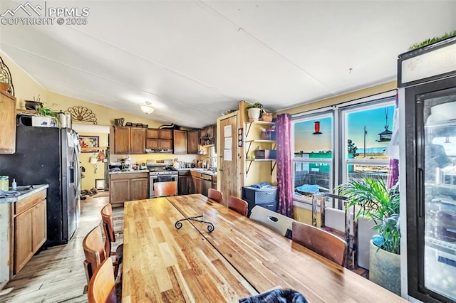 dining space featuring vaulted ceiling and light wood-type flooring