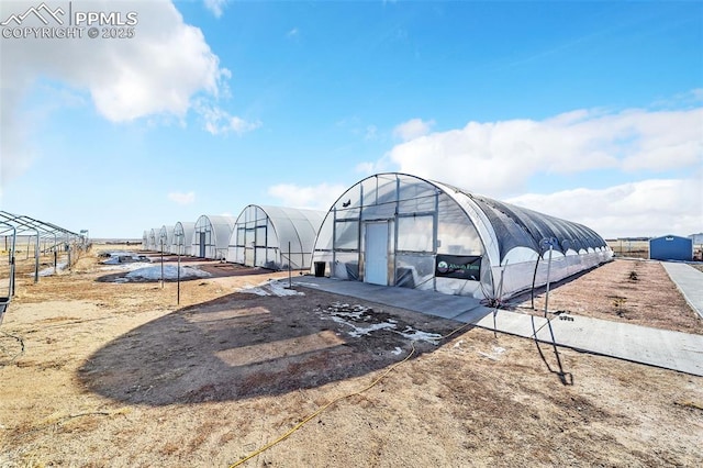 exterior space with a greenhouse and an outdoor structure