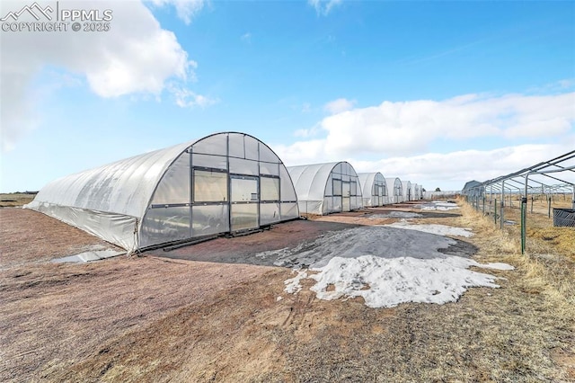 view of greenhouse featuring fence