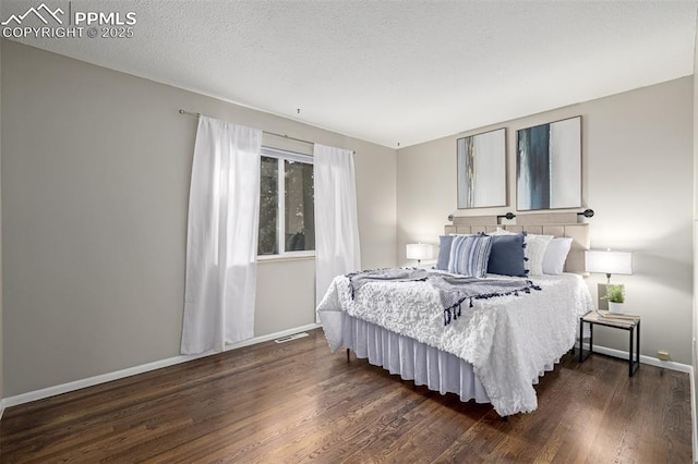 bedroom featuring dark wood-type flooring and a textured ceiling