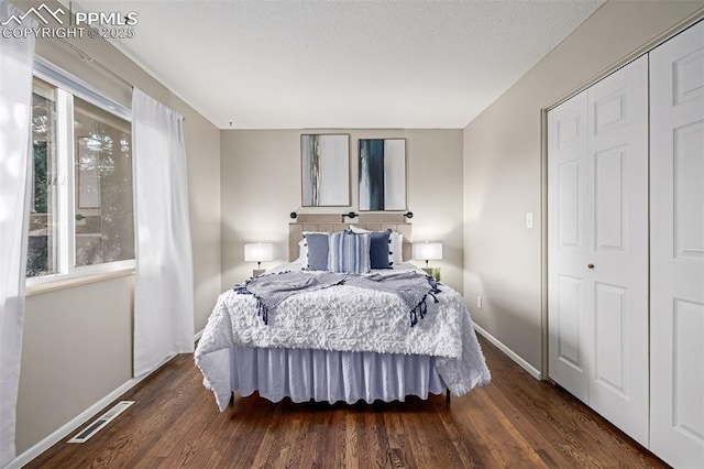 bedroom with dark wood-type flooring and a closet