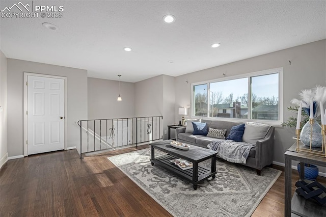 living room featuring dark wood-type flooring and a textured ceiling