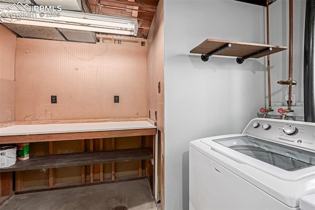 clothes washing area with washer / dryer and a workshop area