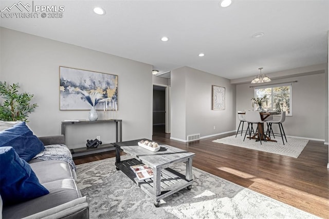 living room featuring dark wood-type flooring and a notable chandelier