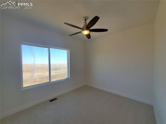 carpeted empty room with ceiling fan, visible vents, and baseboards