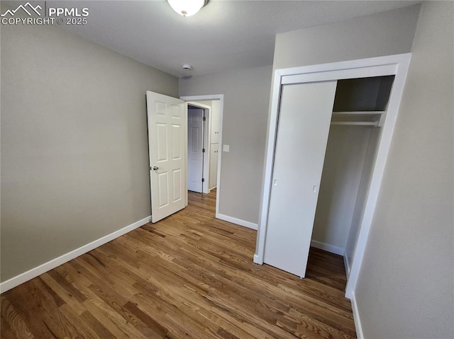 unfurnished bedroom with wood-type flooring and a closet