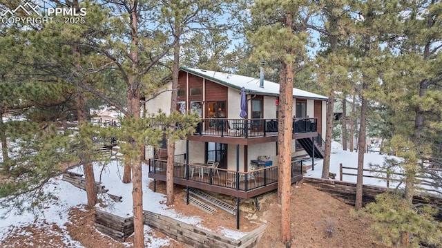 snow covered property with a deck