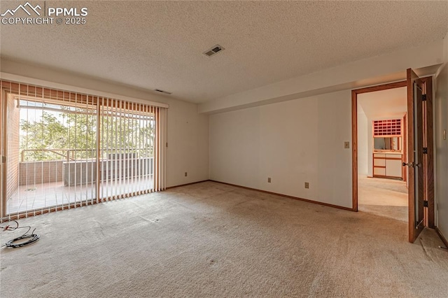 unfurnished room featuring light carpet and a textured ceiling