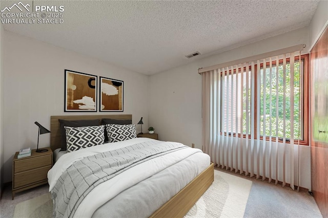 carpeted bedroom with a textured ceiling