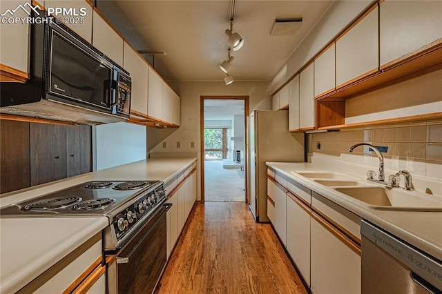 kitchen featuring tasteful backsplash, white cabinetry, appliances with stainless steel finishes, and sink