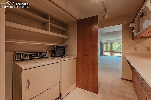 laundry room with track lighting, separate washer and dryer, and light carpet