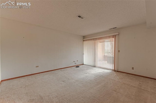 carpeted spare room with a textured ceiling