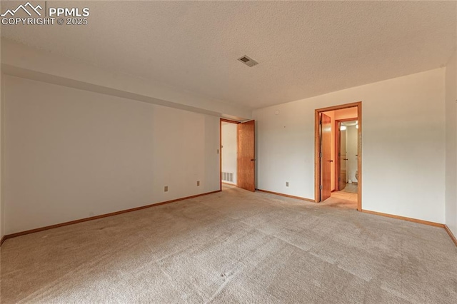 carpeted empty room with a textured ceiling