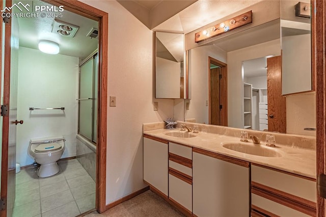 full bathroom featuring tile patterned flooring, vanity, shower / bath combination with glass door, and toilet