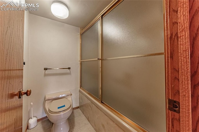 bathroom featuring tile patterned floors, shower / bath combination with glass door, and toilet