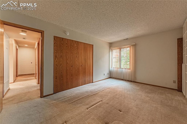 unfurnished bedroom with light colored carpet, a textured ceiling, and a closet