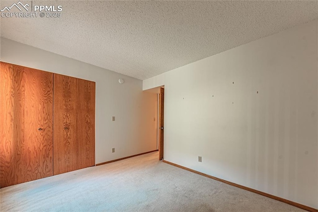 unfurnished bedroom featuring a closet, light carpet, and a textured ceiling