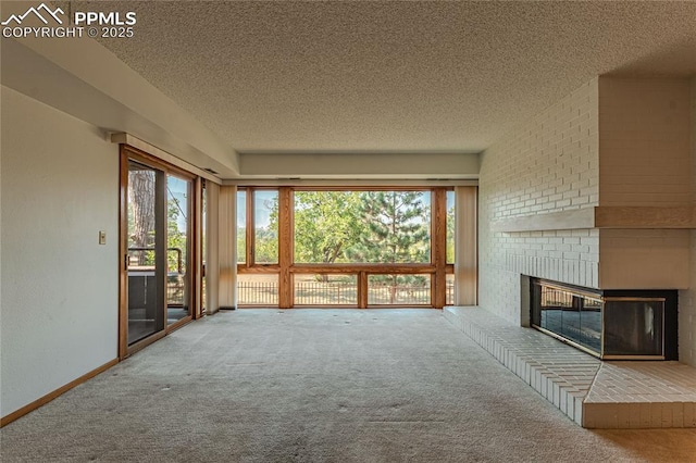 unfurnished living room with a fireplace, carpet floors, and a textured ceiling