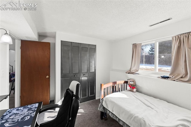 carpeted bedroom featuring a closet and a textured ceiling