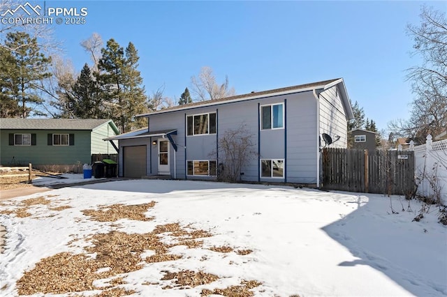 snow covered house featuring a garage