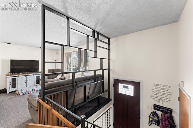 staircase with carpet and a textured ceiling