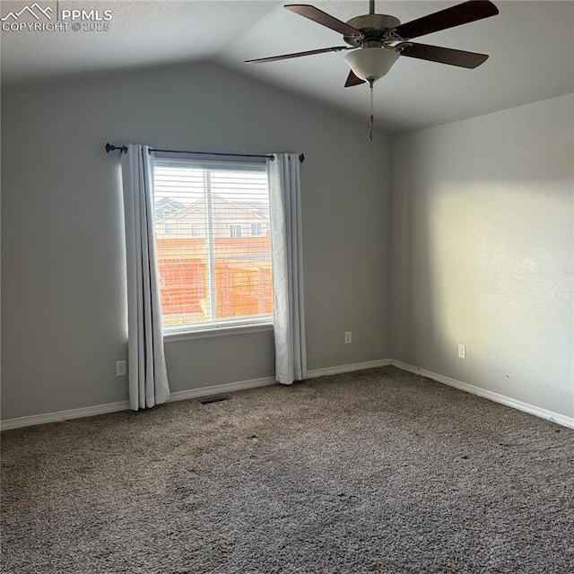 empty room featuring lofted ceiling, ceiling fan, and carpet flooring