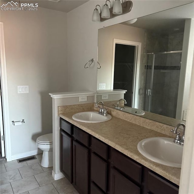 bathroom featuring tile patterned floors, vanity, toilet, and an enclosed shower