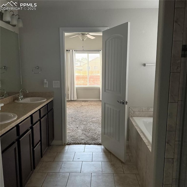 bathroom featuring a relaxing tiled tub, vanity, tile patterned flooring, and ceiling fan