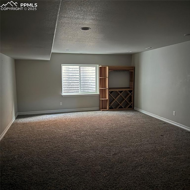 unfurnished room with carpet and a textured ceiling