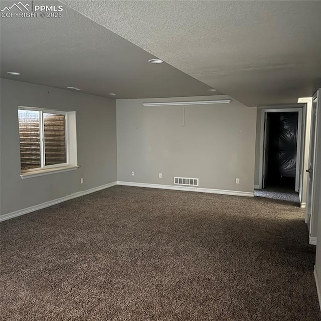 carpeted empty room with a textured ceiling