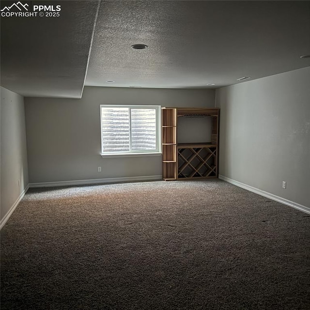 carpeted spare room featuring a textured ceiling