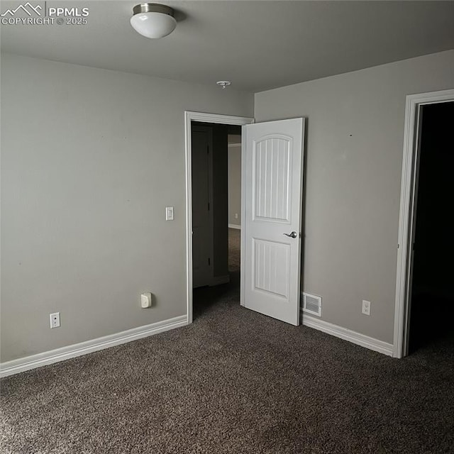 unfurnished bedroom with dark carpet