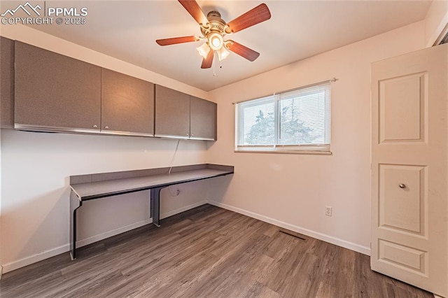 unfurnished office featuring wood-type flooring and ceiling fan