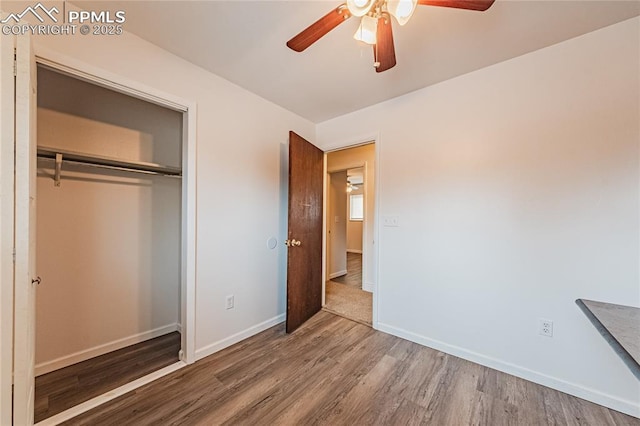 unfurnished bedroom with hardwood / wood-style floors, a closet, and ceiling fan