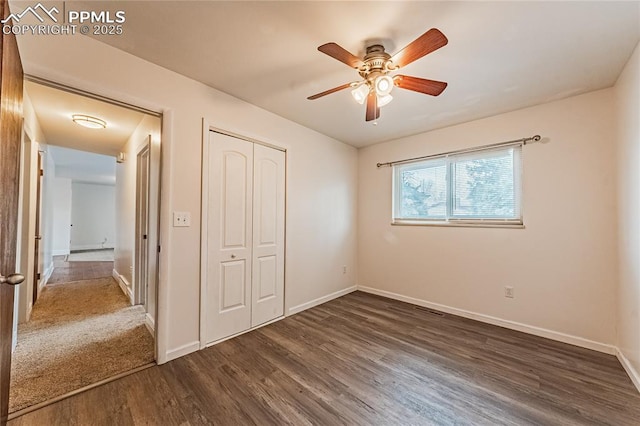 unfurnished bedroom with ceiling fan, dark hardwood / wood-style floors, and a closet