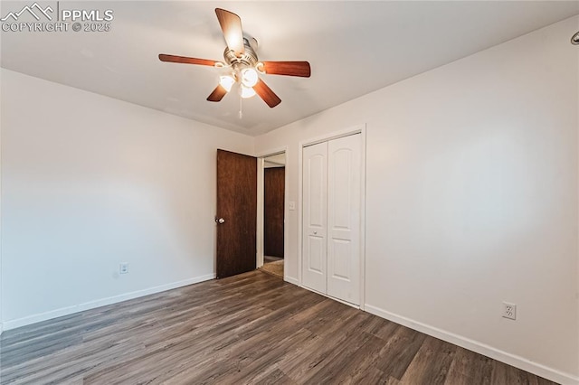 unfurnished bedroom with dark wood-type flooring, a closet, and ceiling fan