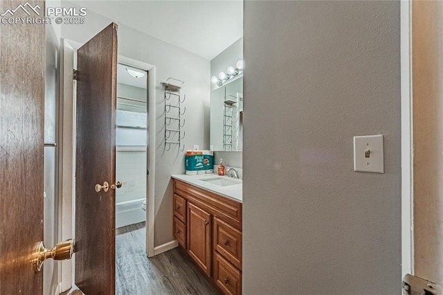 bathroom with vanity, wood-type flooring, and washtub / shower combination