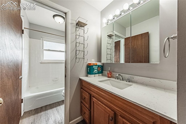 full bathroom featuring tiled shower / bath combo, vanity, wood-type flooring, and toilet