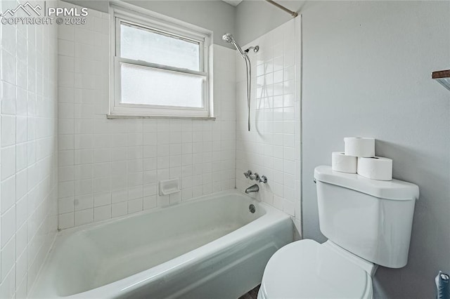 bathroom featuring tiled shower / bath and toilet