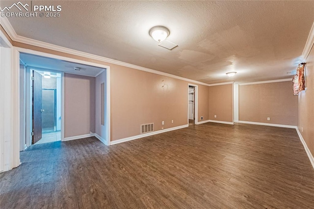 empty room featuring dark wood-type flooring, ornamental molding, and a textured ceiling