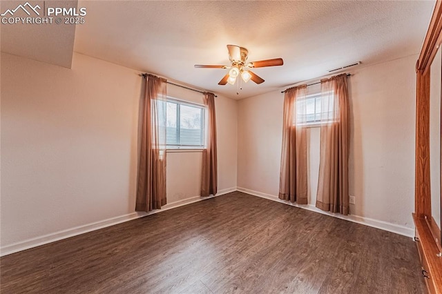 unfurnished room featuring plenty of natural light, dark wood-type flooring, a textured ceiling, and ceiling fan