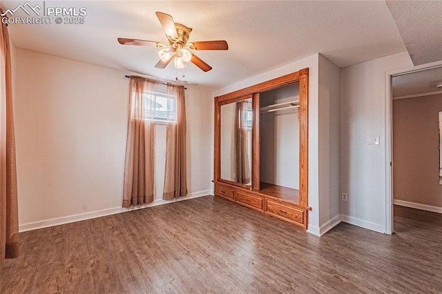 unfurnished bedroom featuring dark wood-type flooring, a closet, and ceiling fan